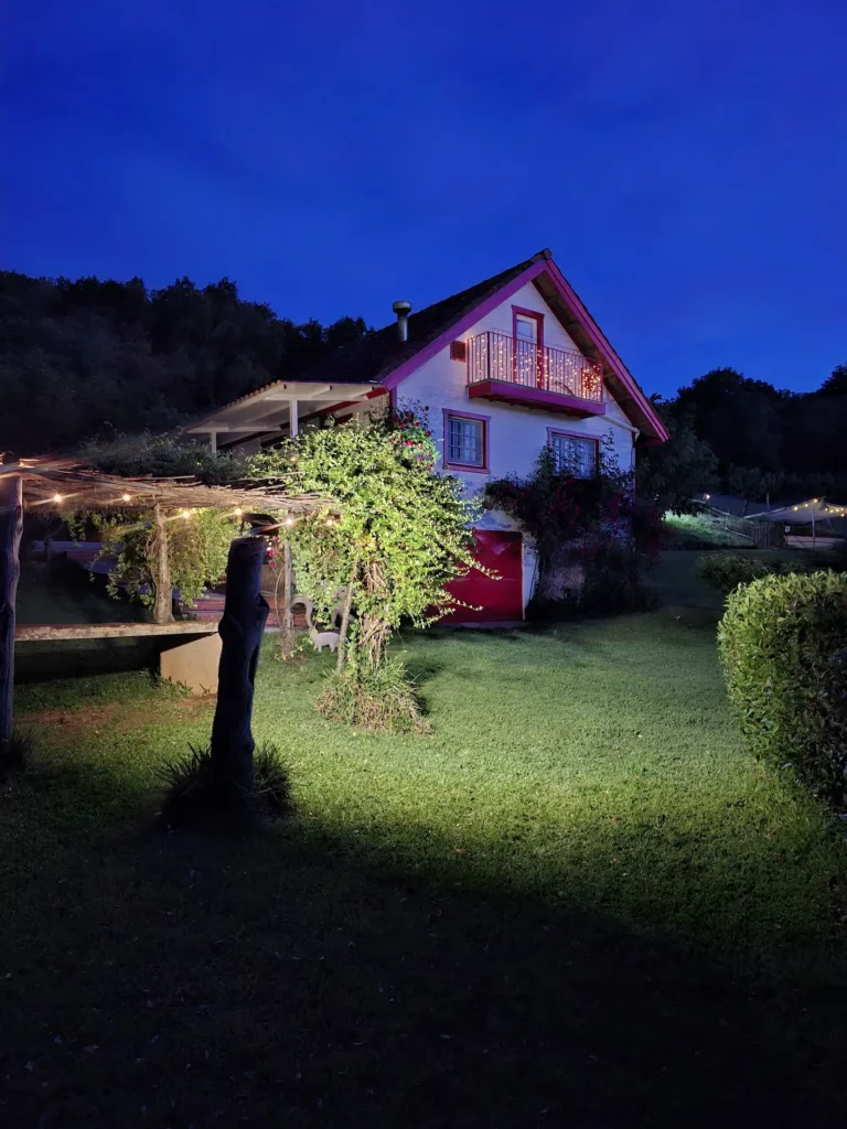 Vista de la casa con el jardín iluminado por la noche