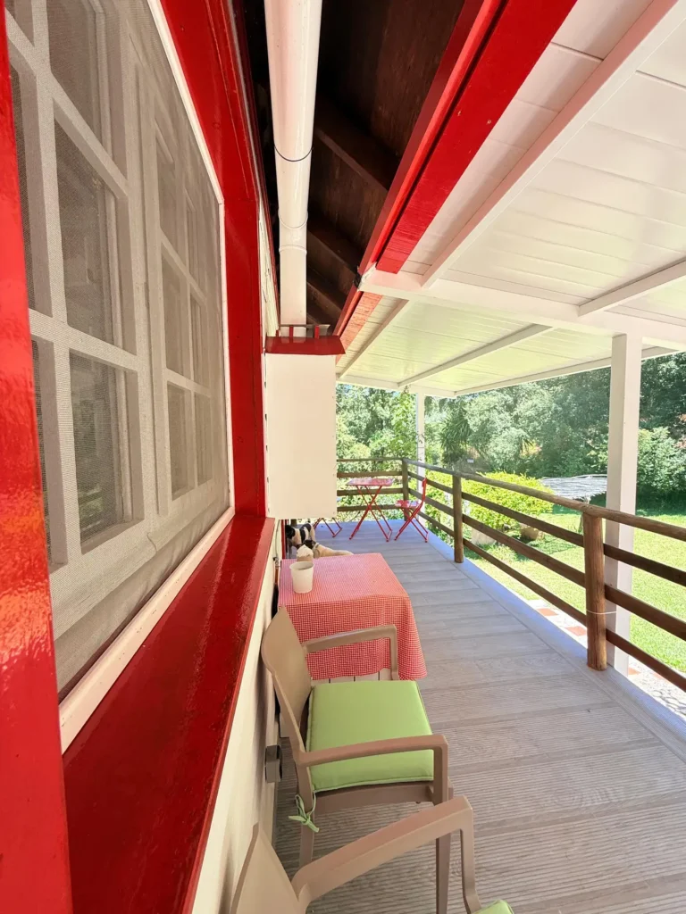 Una terraza con varias sillas y mesas con vistas al jardín