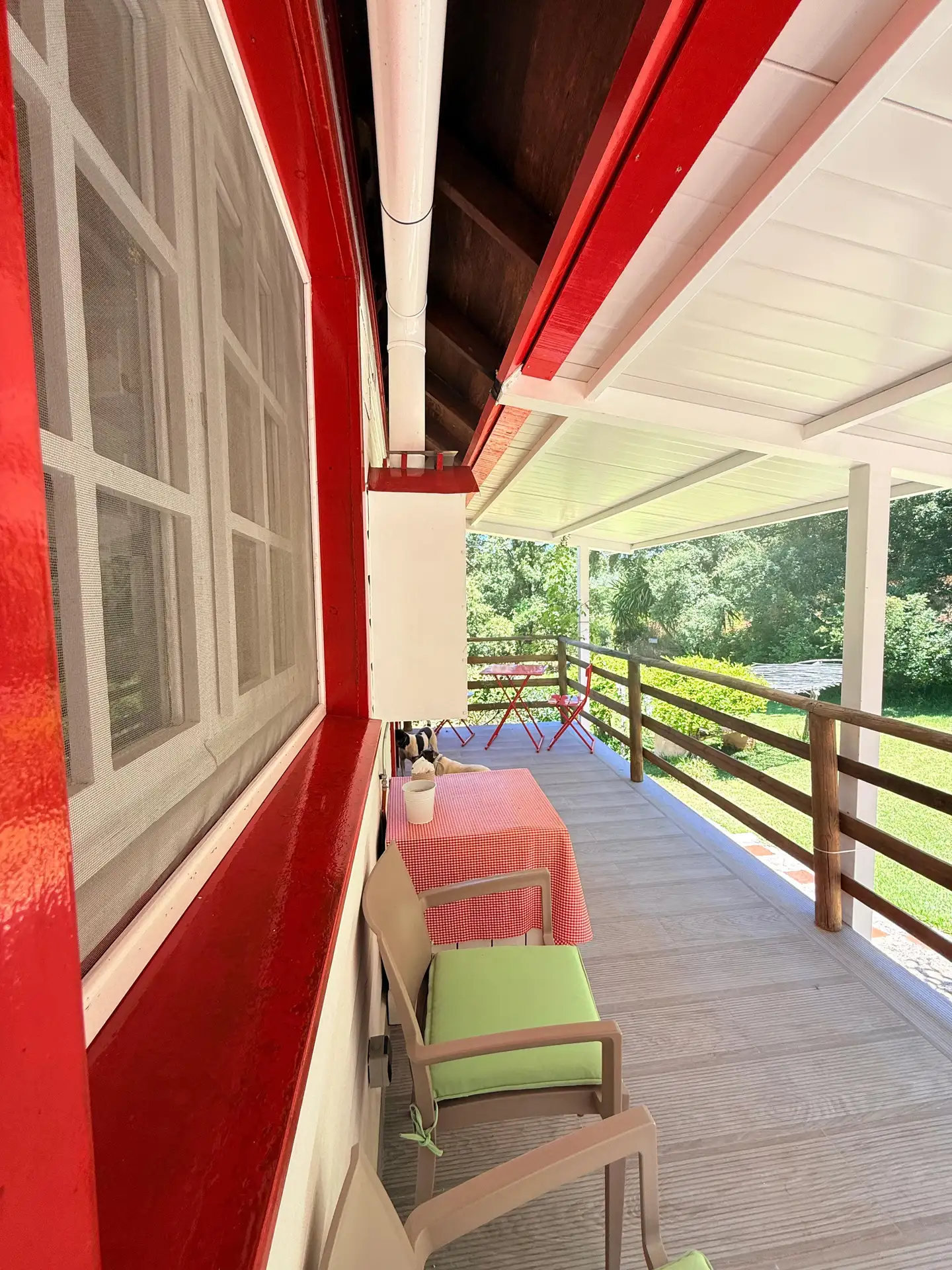 Una terraza con varias sillas y mesas con vistas al jardín