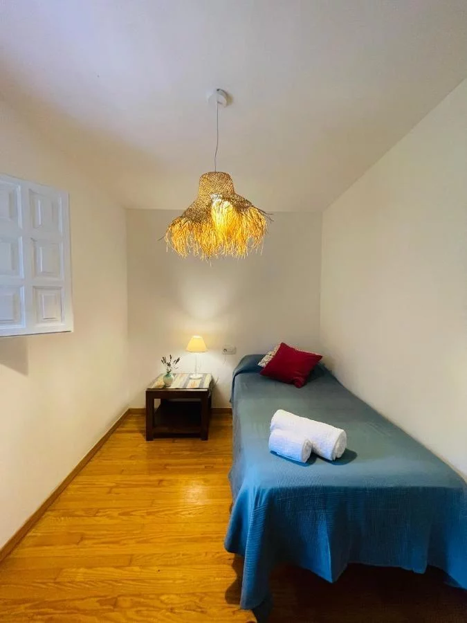 Habitación individual con una cama y mesilla de noche